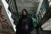 Woman in Black Hijab Standing Near Black Metal Railings
