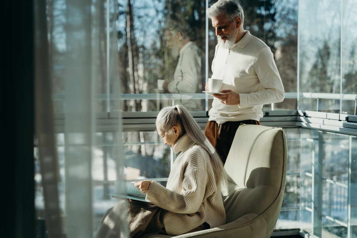An elderly couple enjoying a peaceful moment by a bright window