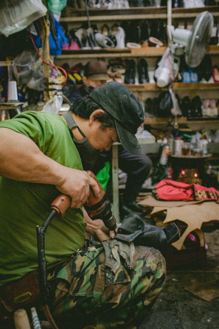 Shoemaker Working In Workshop