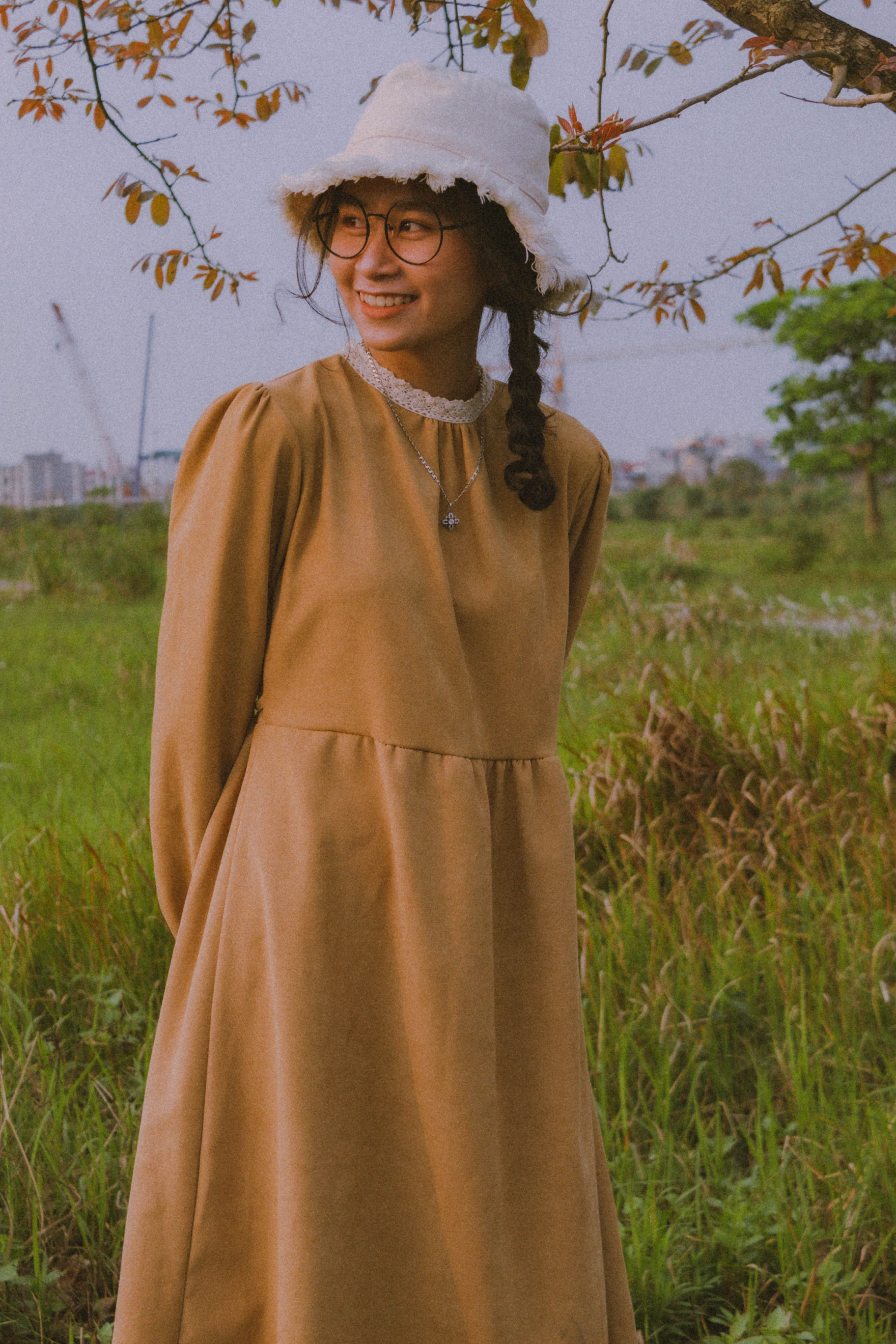 A Pretty Woman in Yellow Dress Sitting on a Grassy Field · Free Stock Photo