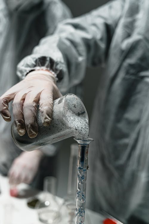 Person Pouring Water on Clear Glass