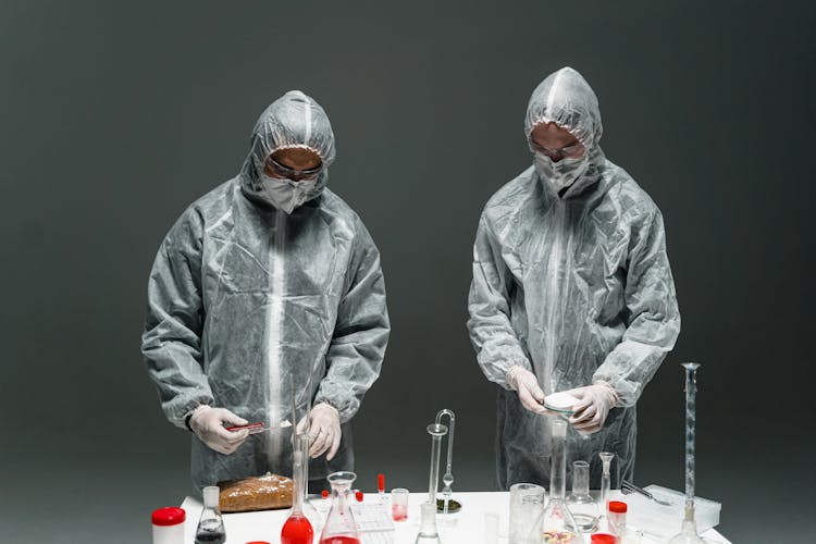 Two People Wearing Protective Suits In Science Laboratory