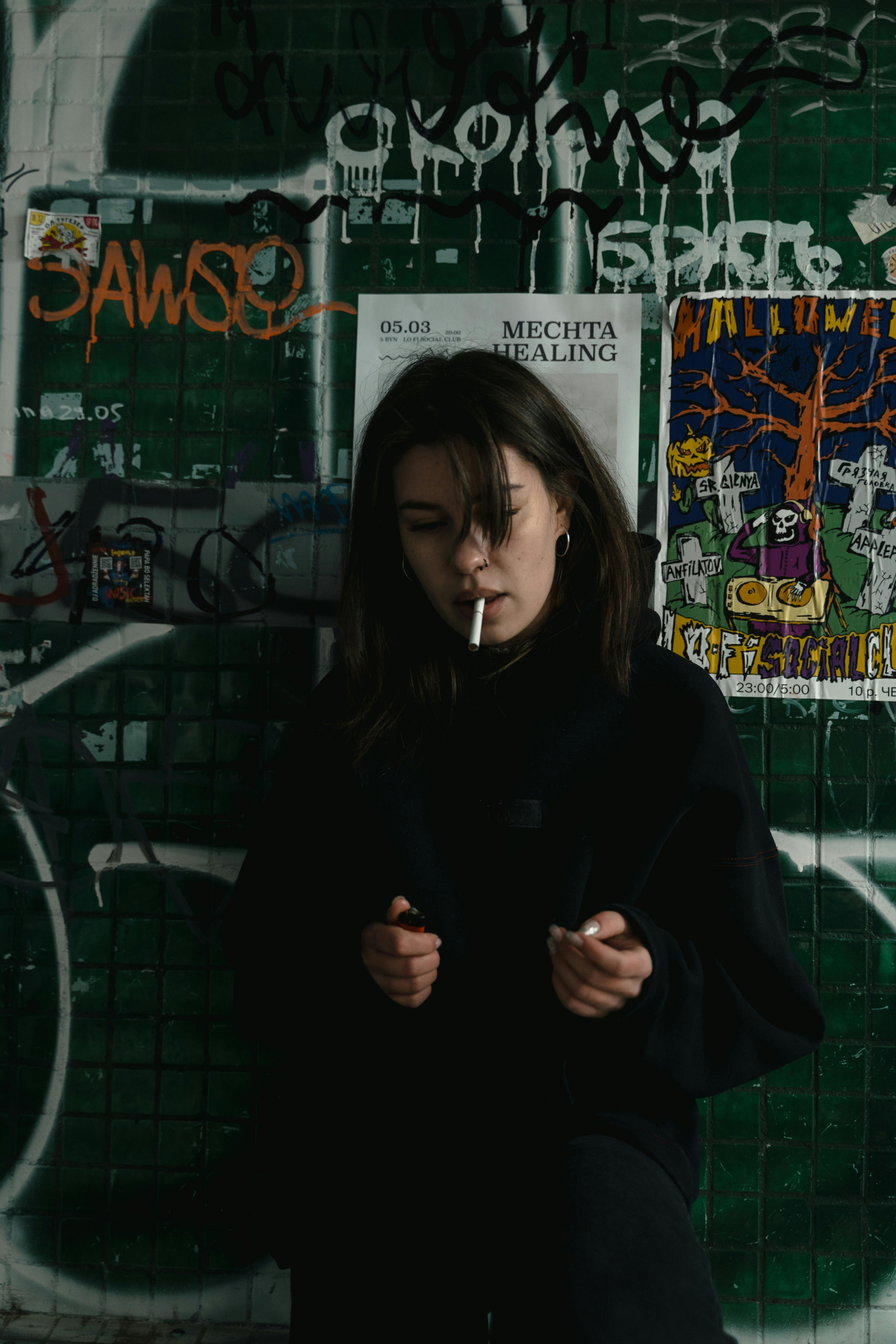 woman in black hoodie smoking cigarette