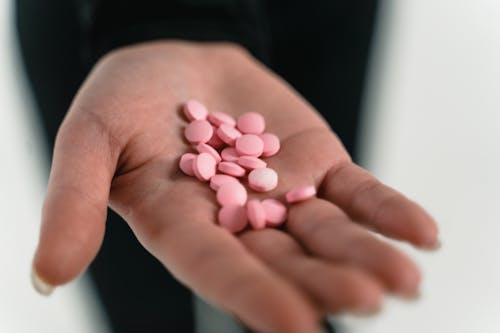 White Round Medication Pill on Persons Hand