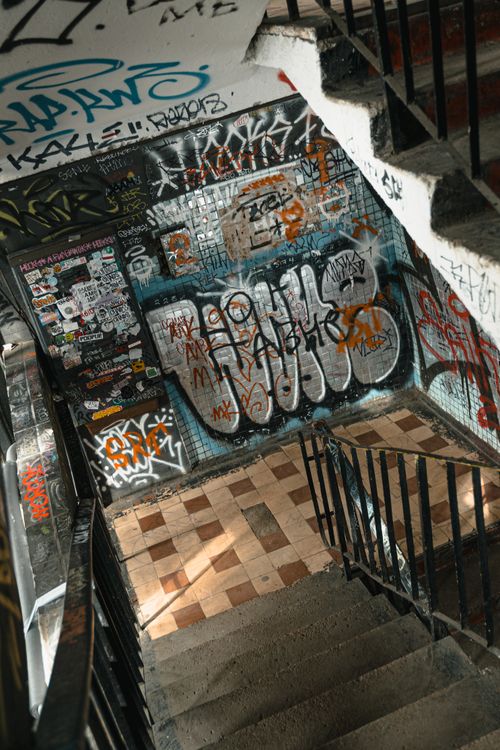 Free Colorful graffiti adorns an urban stairwell's walls, showcasing vibrant street art. Stock Photo