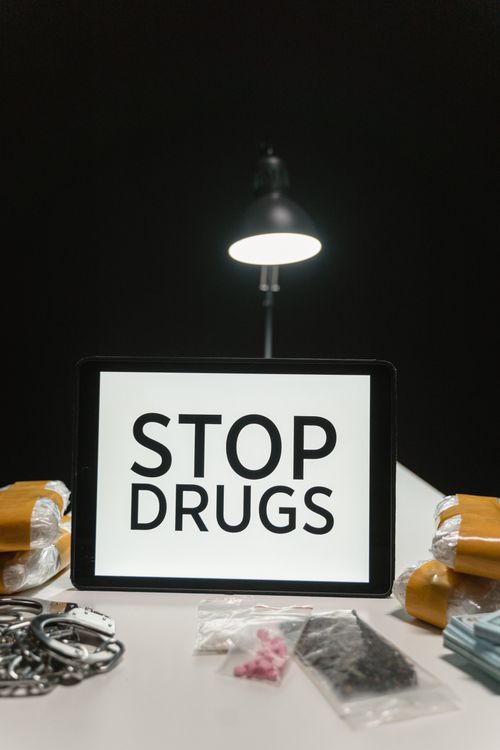 Free A conceptual photo highlighting anti-drug message with paraphernalia on a black background. Stock Photo