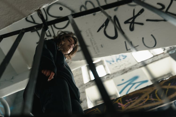 Low-Angle Shot Of A Woman In Black Top Walking Down The Stairs