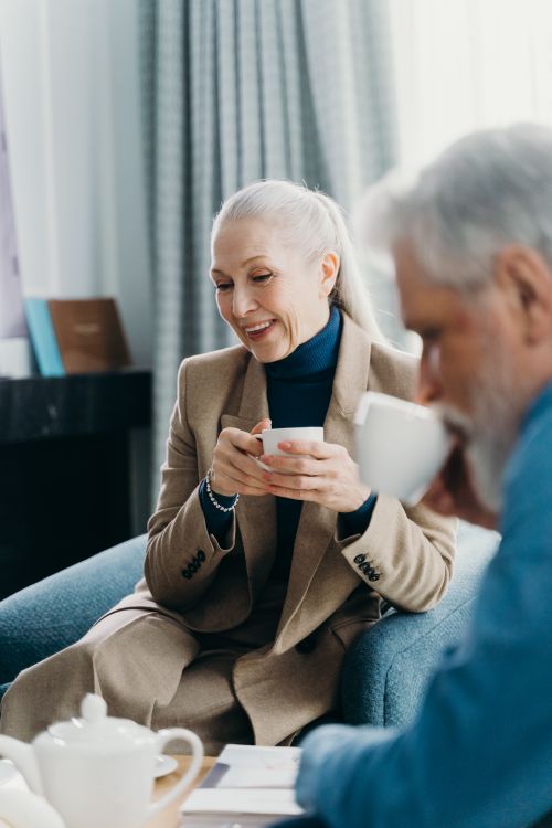 Free Senior adults sitting indoors, warmly engaged over coffee in a cozy, relaxed atmosphere. Stock Photo