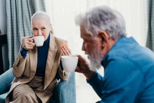 Free Senior couple enjoying coffee and conversation in a cozy indoor setting. Stock Photo