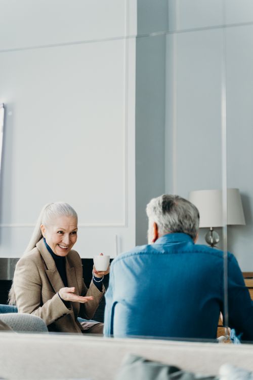 Free A senior couple enjoying relaxation and conversation with a cup of coffee indoors. Stock Photo