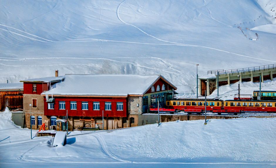 Traveler holding a Swiss Travel Pass at a modern train station in Switzerland