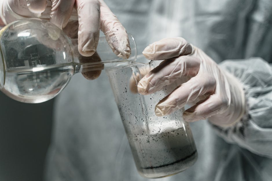 Close-up of scientist pouring liquid in laboratory experiment, wearing gloves.