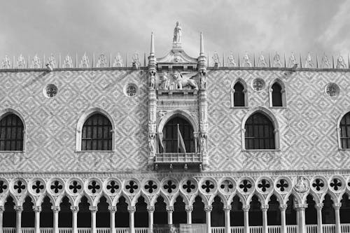 Free Black and white of old art museum exterior with sculptures and decorative colonnade under cloudy sky in Venice Italy Stock Photo