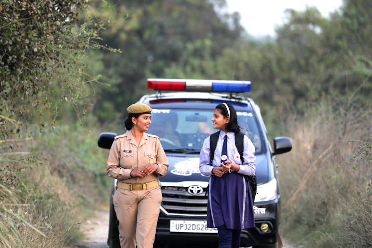 A Female Law Officer Walking With A Student