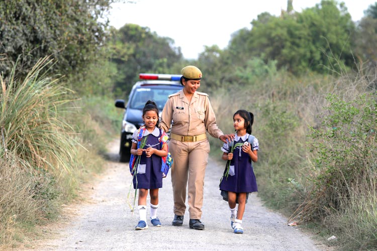 Woman Police Officer Walking Two Little Girls