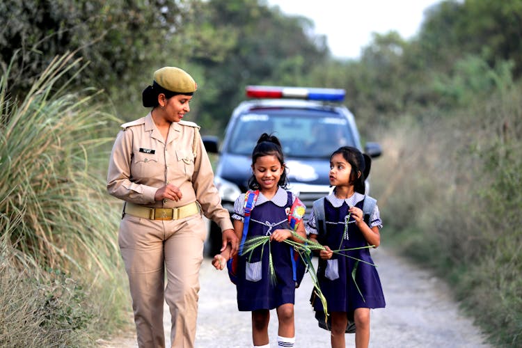 Police Officer Walking With Girls In Woods