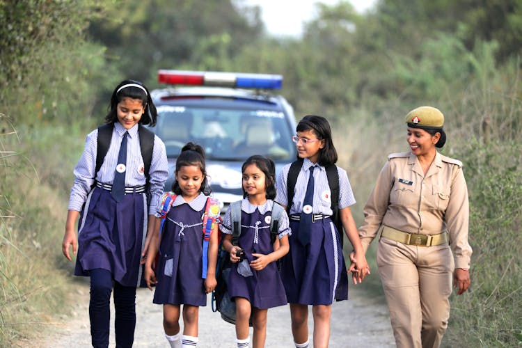 Group Of Young Girls Walking With A Police Woman