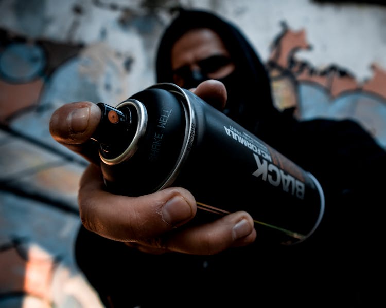 A Person Holding A Spray Paint Canister