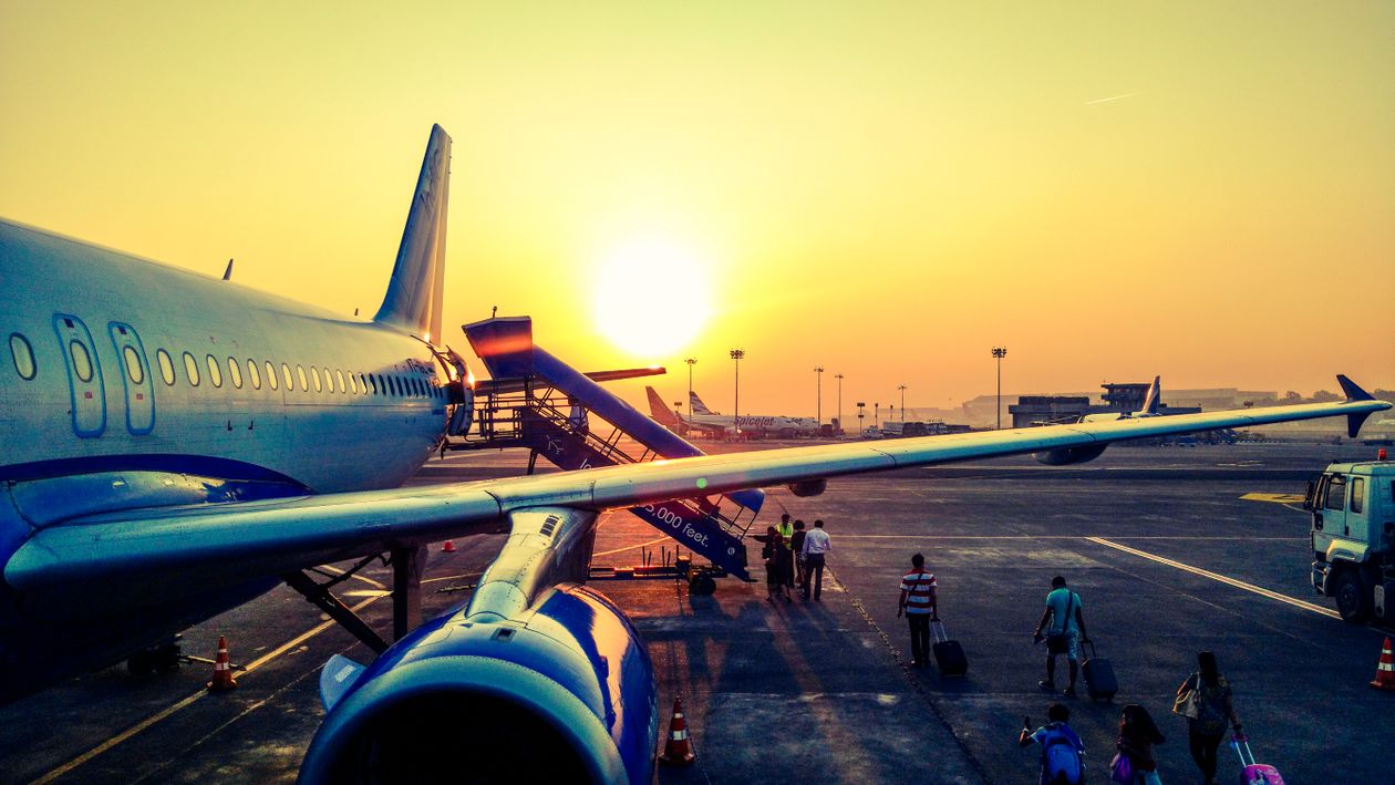 Jet engine and aircraft wing on the tarmac at sunset