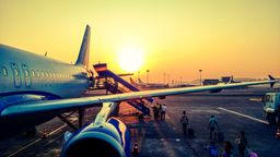 An aircraft waiting at the gate as the sun goes down