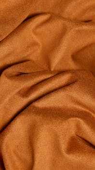 Detailed close-up of crumpled brown fabric with a shiny, soft texture.