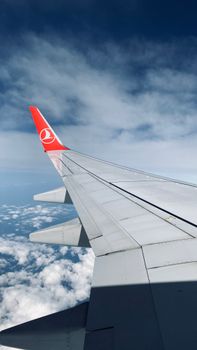 View from airplane window showing the wing and a beautiful sky during flight.