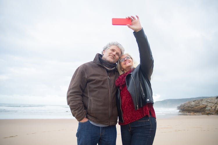 A Couple Taking A Selfie On The Beach