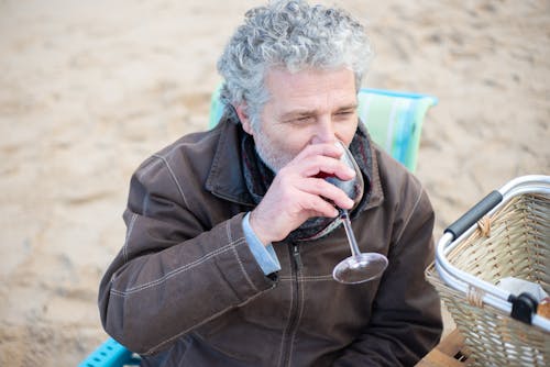 Man in Brown Jacket Drinking a Wine