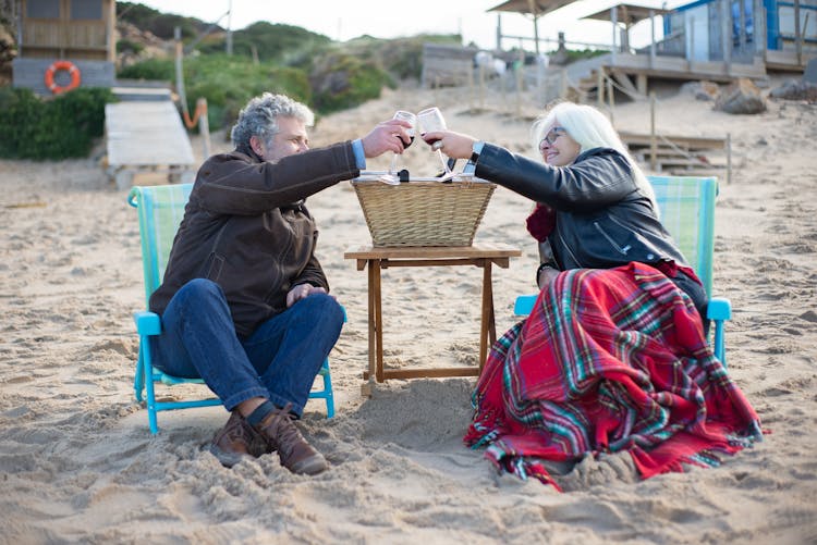 Couple Sitting On Beach Chairs