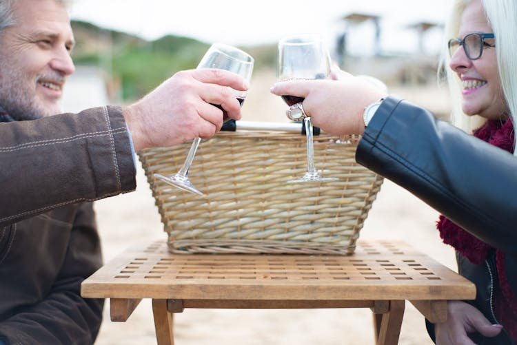 Photograph Of An Elderly Couple Toasting Glasses Of Wine