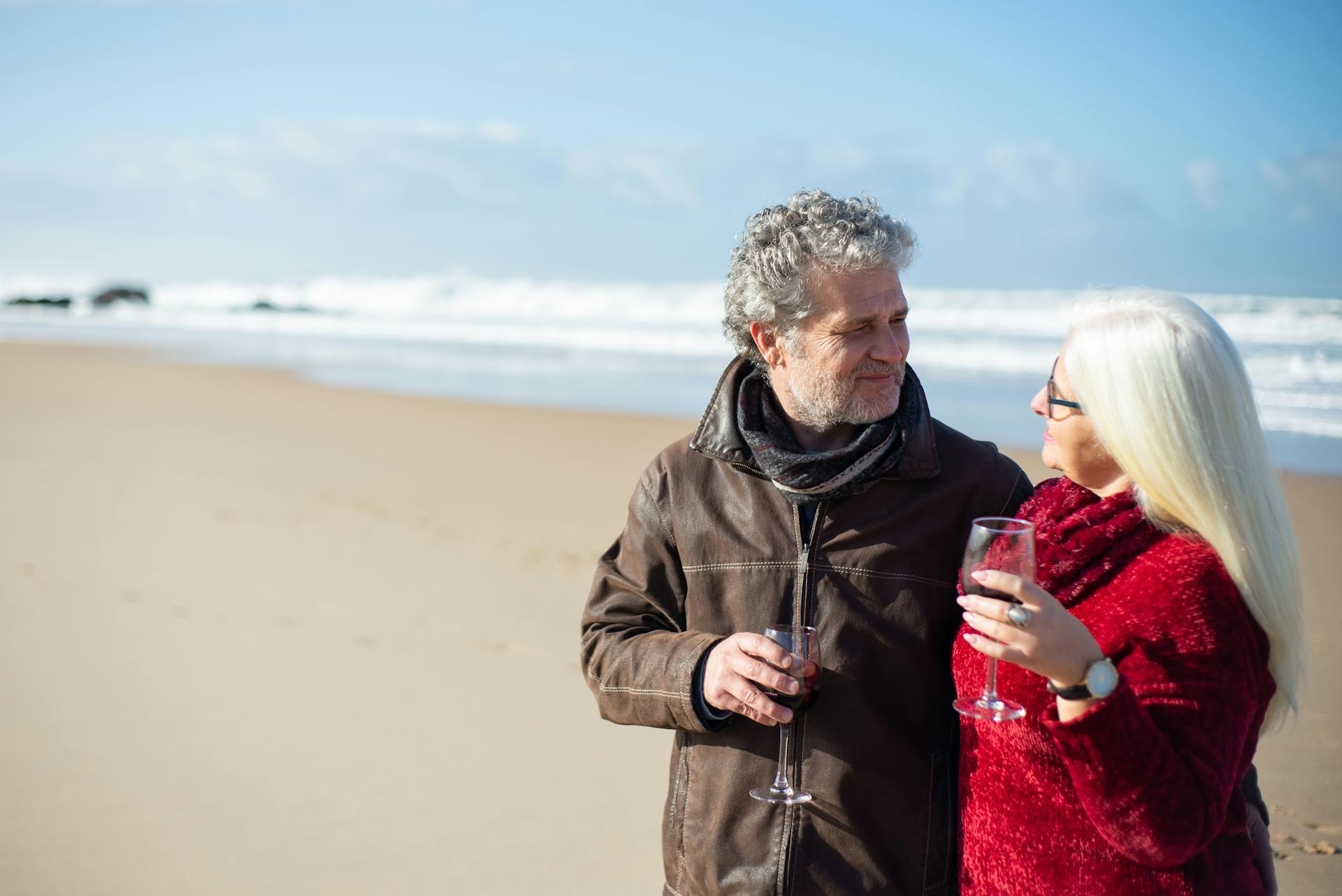 Senior couple enjoying a romantic day with wine on a beach in Portugal.