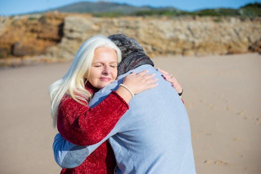 Senior couple sharing a warm embrace on a sunny beach in Portugal, showcasing love and companionship.