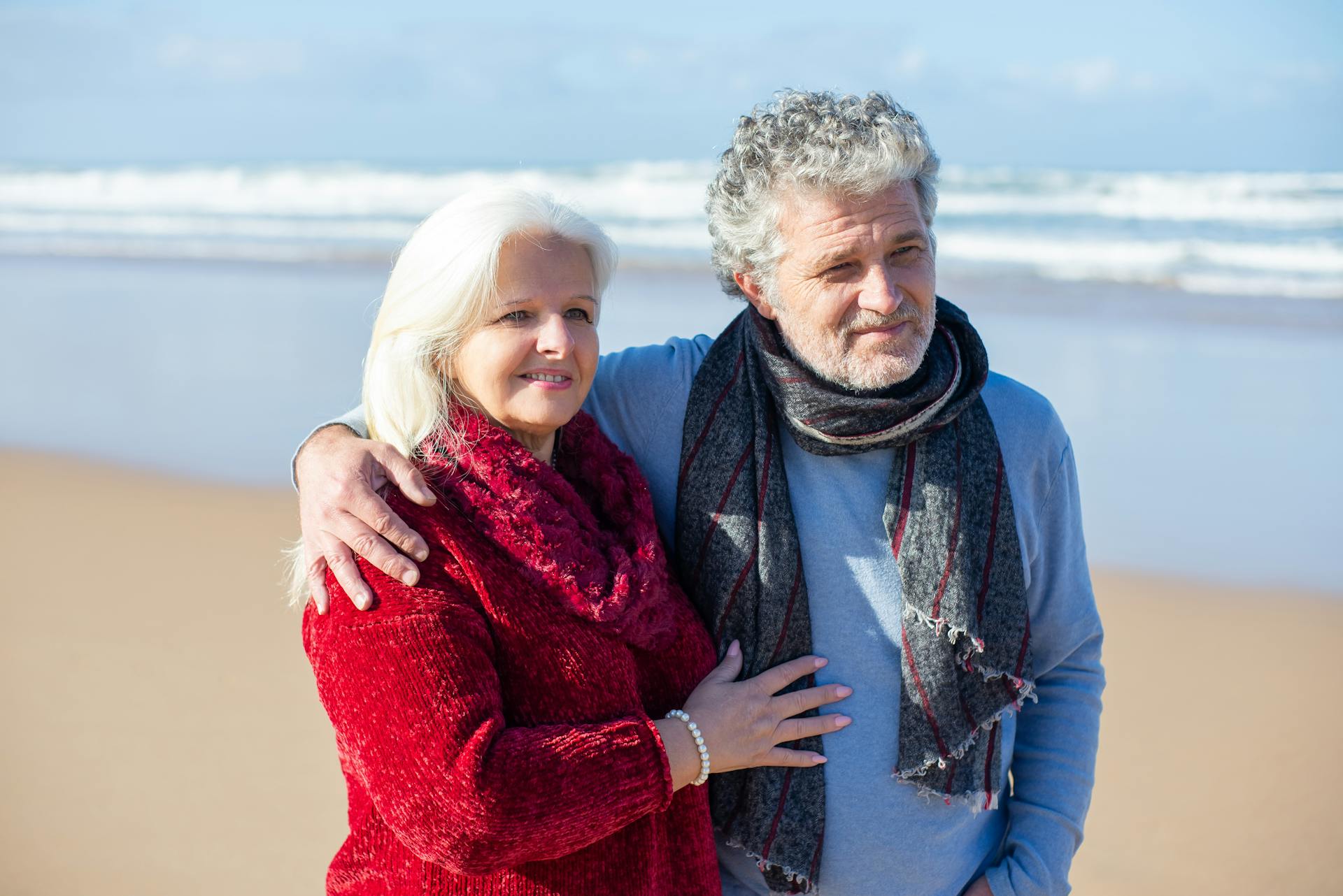 Romantic senior couple embracing at a sunny beach in Portugal.