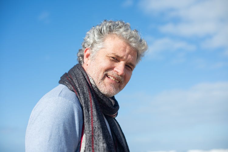 A Fine Looking Elderly Man In Blue Shirt And Gray Scarf