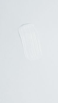 Single white brush stroke on a light background, showcasing simplicity and abstract art.