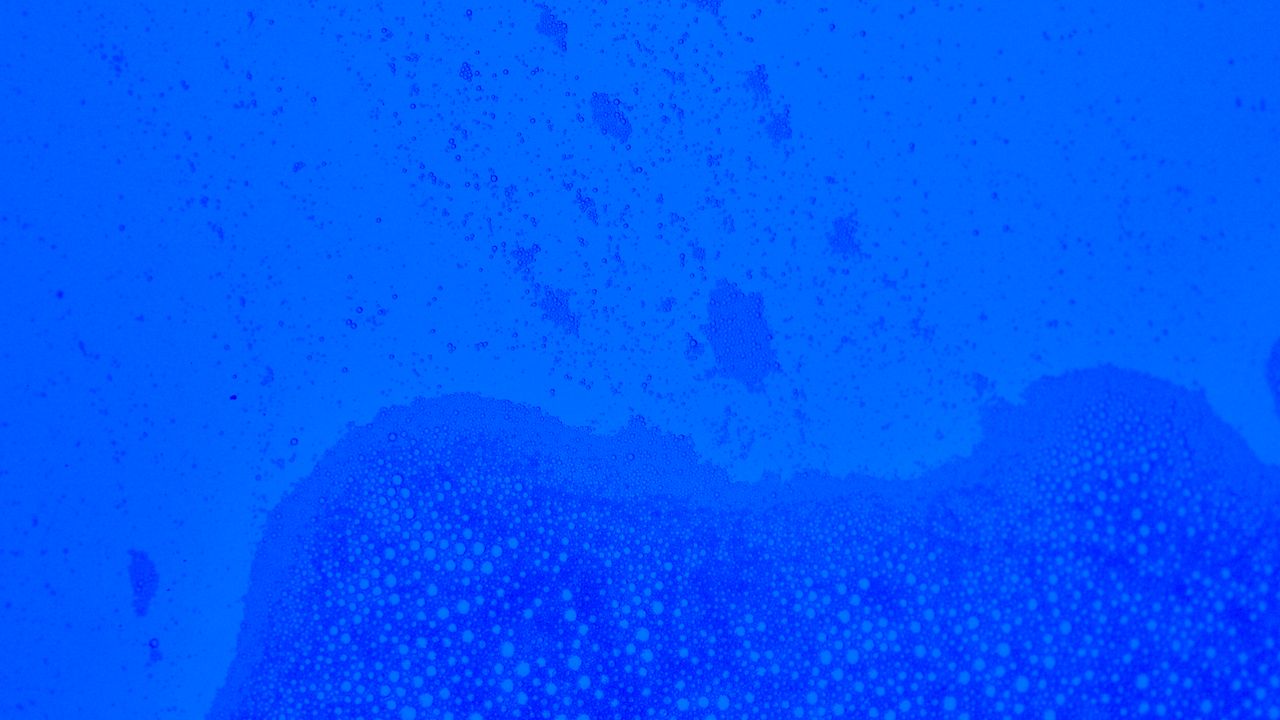 a vibrant abstract blue texture featuring an intricate pattern of bubb