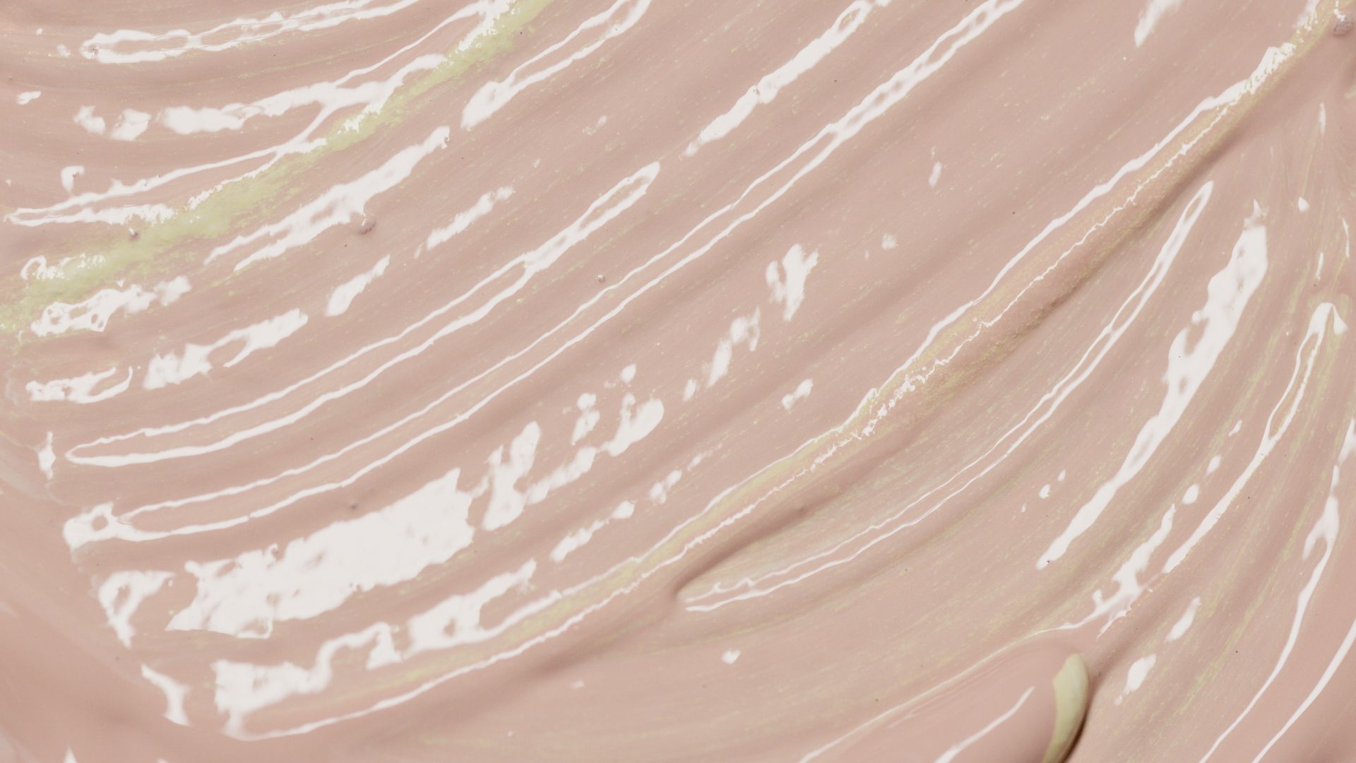 Abstract close-up of beige paint with visible brush strokes and reflections.