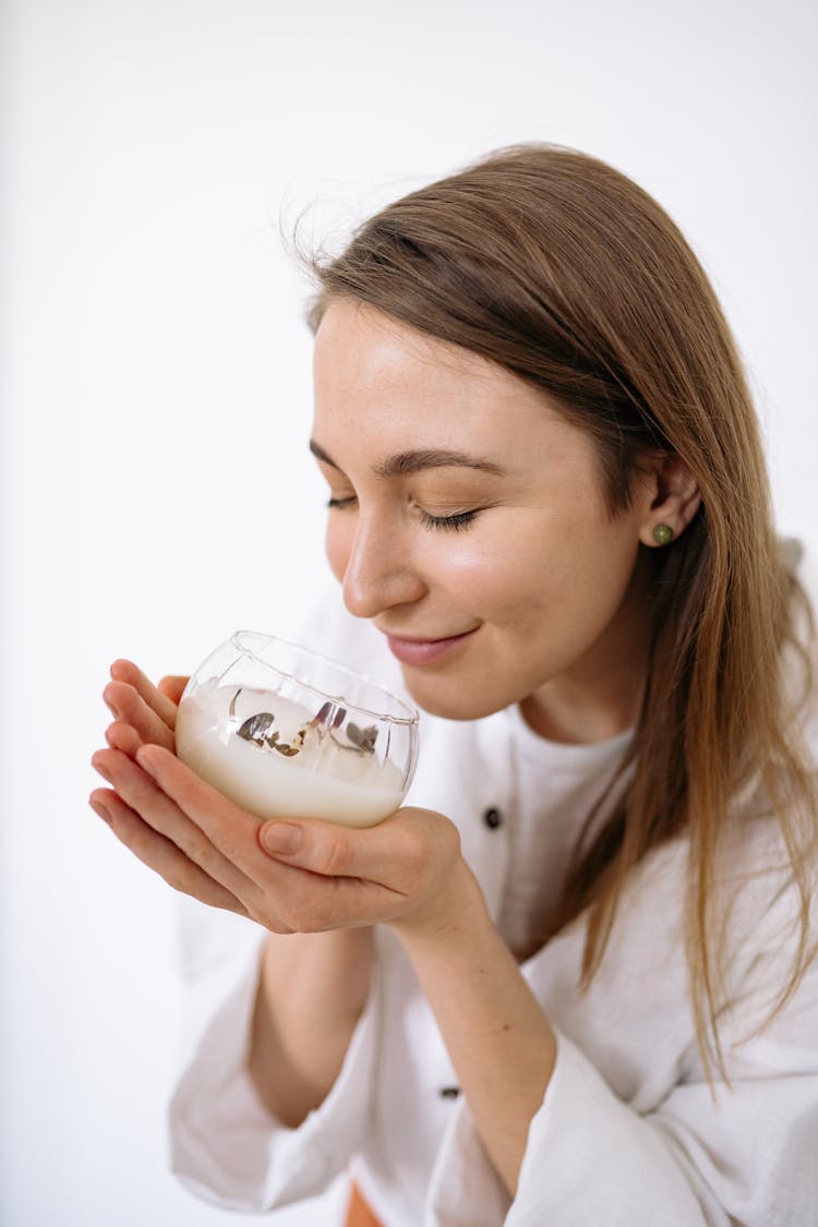 A Woman Holding A Scented Candle