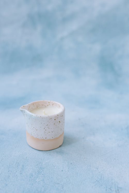 Free A Candle in a White Speckled Container  Stock Photo