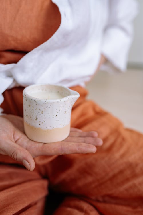 A Speckled Container on a  Person's Hand