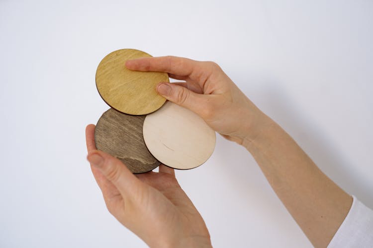 A Person Holding A Wooden Round Coasters