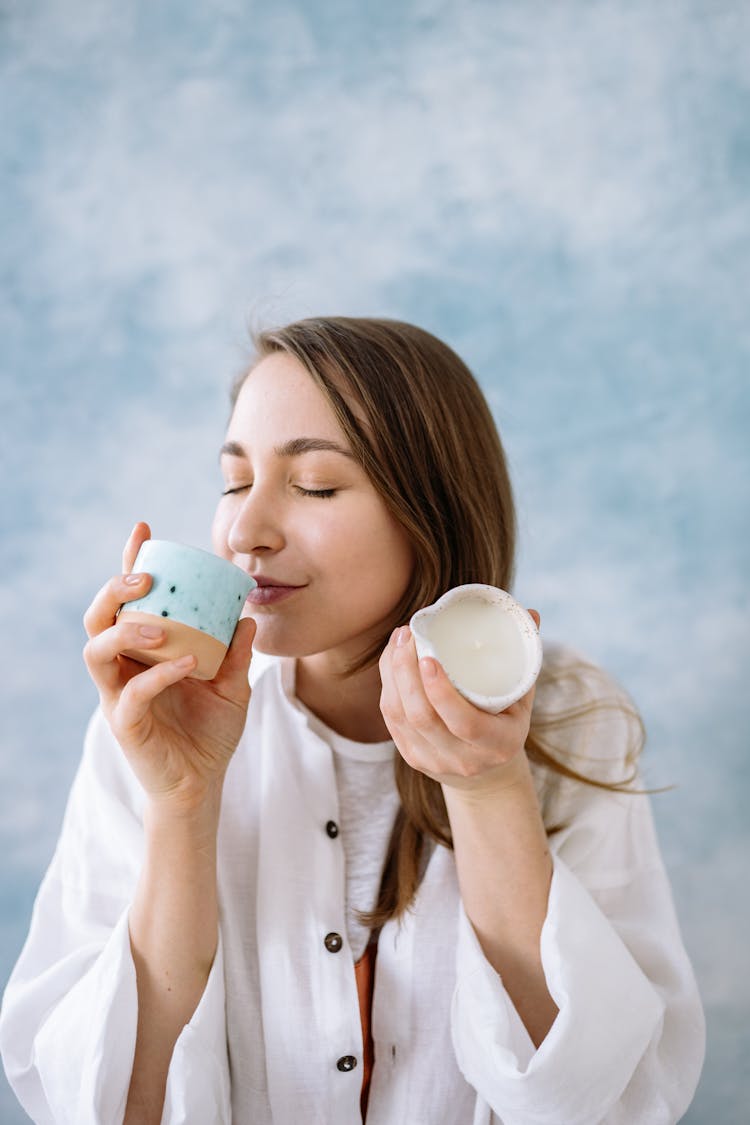 Woman Smelling A Scented Candle