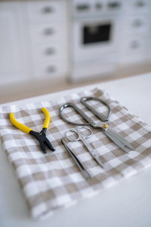A Variety of Cutting Tools on a Plaid Fabric