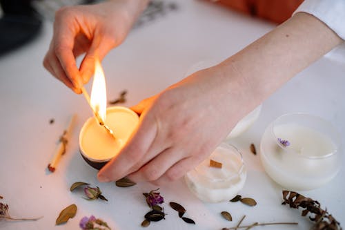 Person Lighting Up White Candle