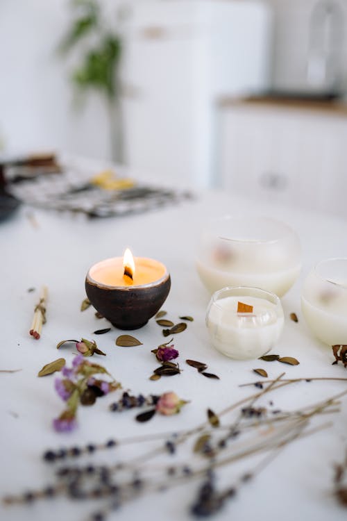 Free Scattered Leaves and Flowers and a Burning Candle Stock Photo