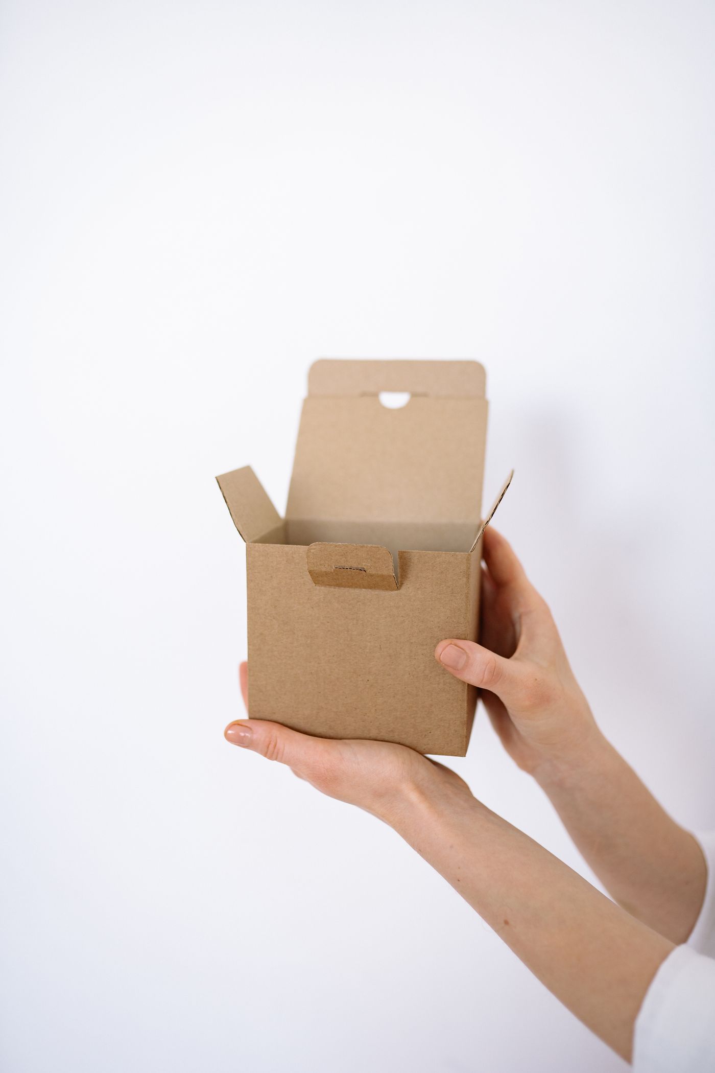 Hände verpacken einen Karton für den Versand