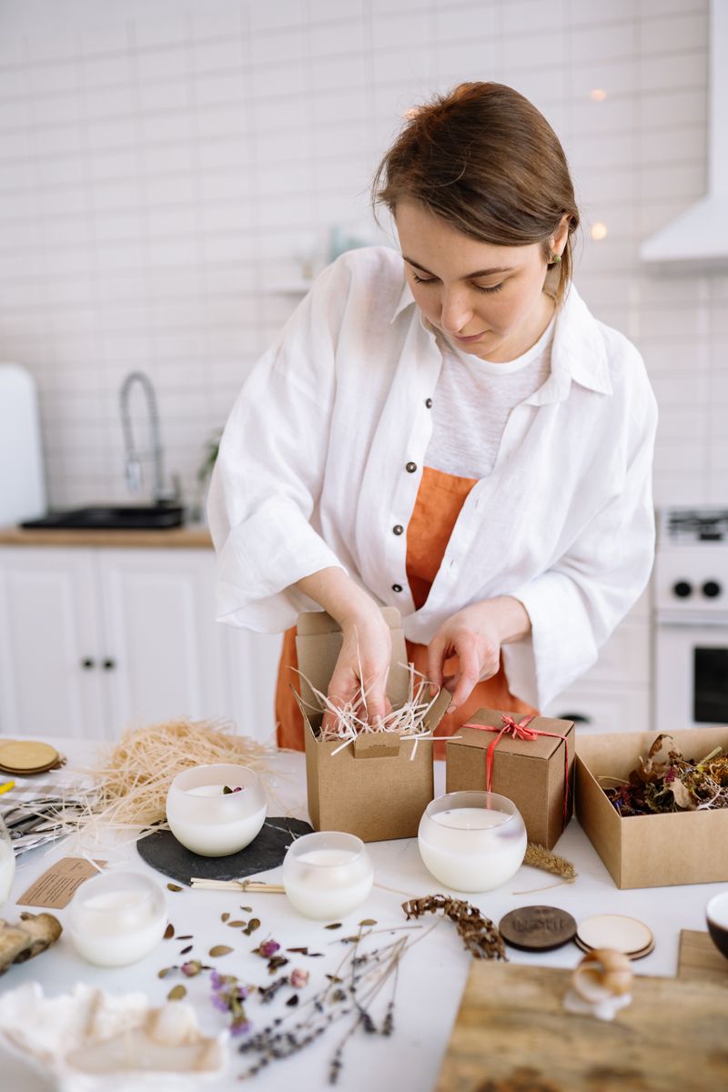 Maker packing handmade candles into a box — photo by Yan Krukau on Pexels
