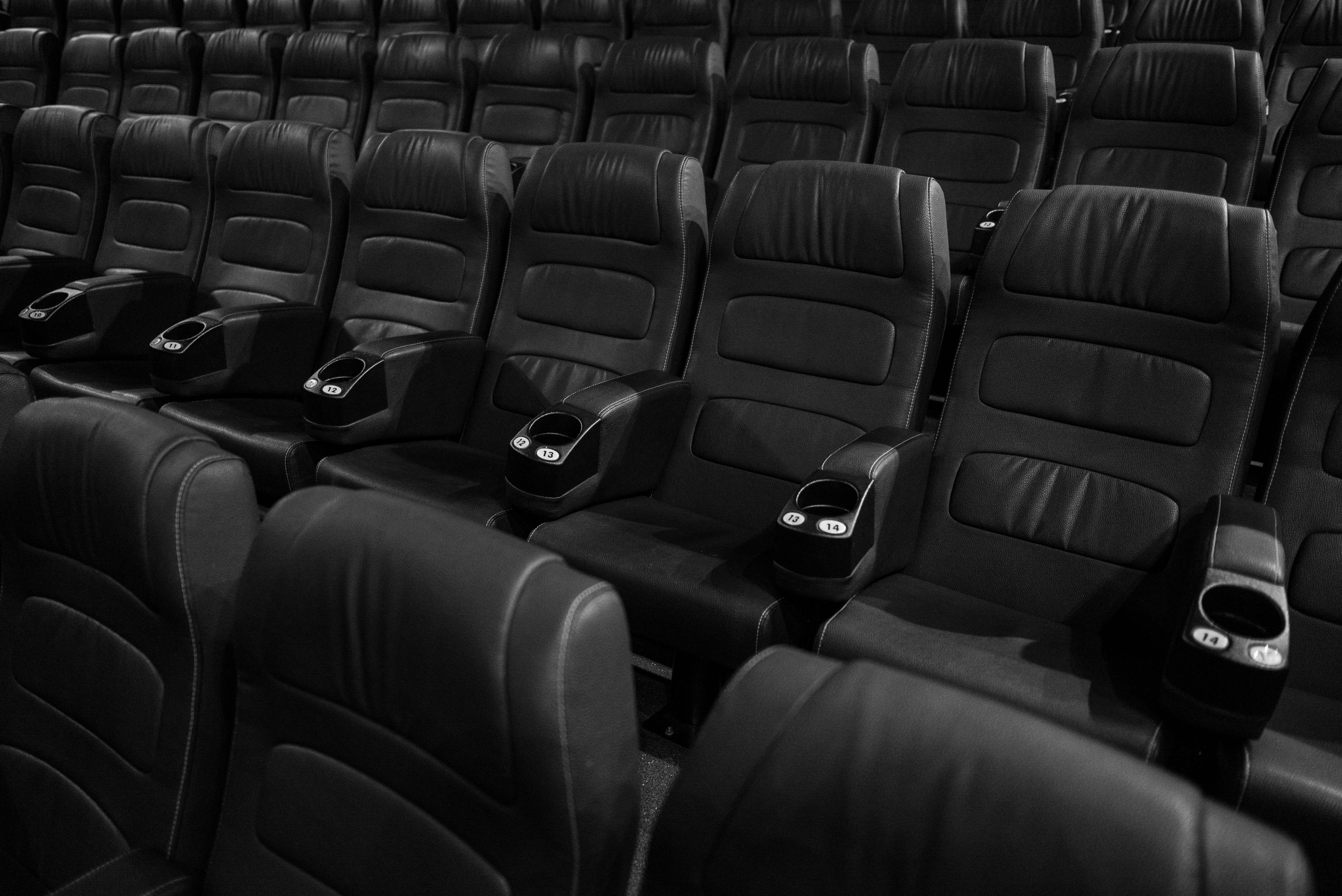 grayscale photo of empty seats in movie theater