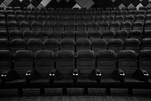 Free Rows of empty seats in a movie theater, presented in a dramatic black and white photo. Stock Photo