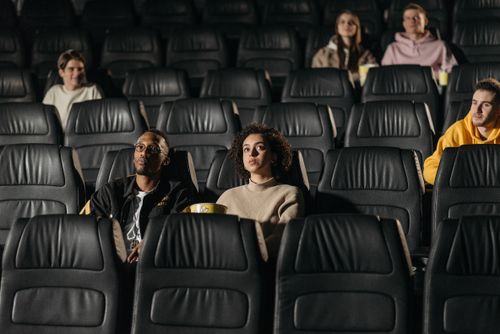 Free Cinematic audience sitting in comfortable seats, engrossed in a movie experience. Stock Photo